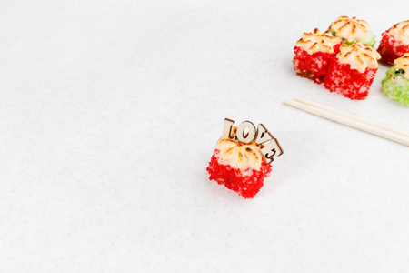 Sushi Valentine's Day. Love sushi rolls. Sushi rolls, chopsticks and the inscription love on a light background.の写真素材