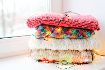 A stack of knitwear on the window. Garland on a pile of things.の写真素材
