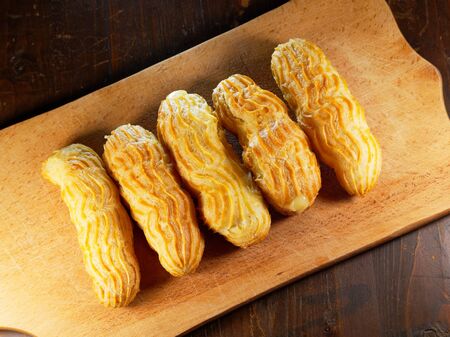 Eclairs on a cutting board. Sweet still life.の写真素材