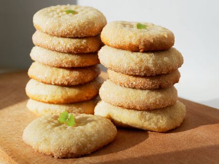 Sugar cookies on a wooden background. Two piles of fresh cookies.の写真素材