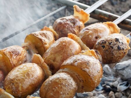 A delicious snack for a party on the nature. Potatoes cooked on the fire. Barbecue without meat.の写真素材