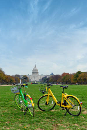 Washington, D.C., USA - November 12, 2017: Two bicycles, parts of the dockless bike-sharing system, are standing on the lawn near the US Capitol Building.のeditorial素材