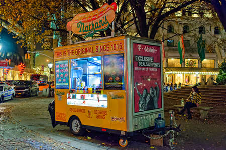 New York City, USA - December 2, 2017: The traditional street food cart selling hot dogs, french...