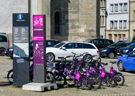 Fribourg (Freiburg), Switzerland - September 3, 2019: The PubliBike station, part of the Swiss bike-sharing system, is surrounded by cars on a parking lot in city center.のeditorial素材