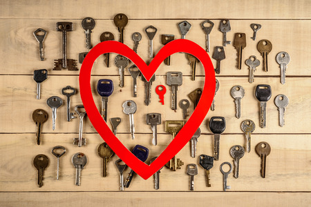 eart and many different keys lie on a wooden tableの写真素材