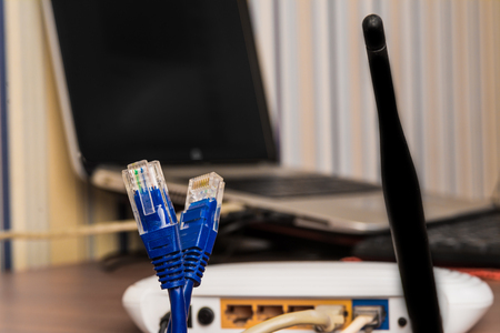 cables for internet connection wifi router with antenna and laptop