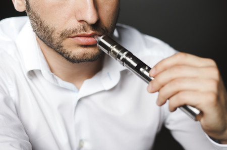 Man with concealed identity smoking a controversial vape