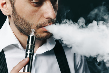 Caucasian man in white shirt vaping