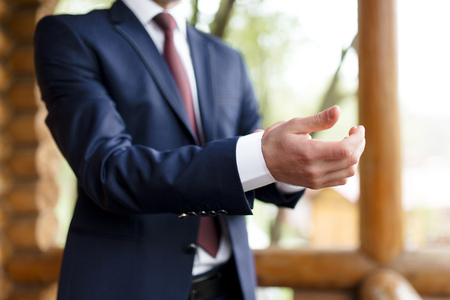 Man in blue suit putting on the cuff linksの写真素材