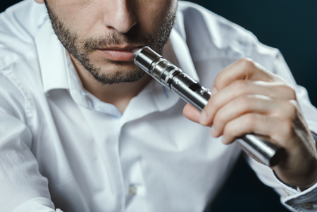 Caucasian man in white shirt vapingの写真素材