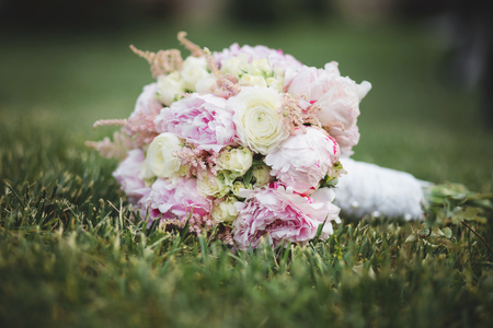 Beautiful  wedding bouquet laying on the green lawnの写真素材