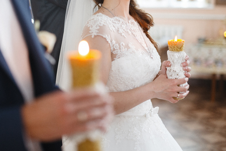 Couple holding candles during wedding ceremony in orthodox churchの写真素材