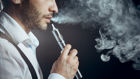 Caucasian man in white shirt vapingの写真素材