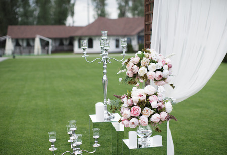Outdoors wedding decoration with flower bouquets, candles and garlandsの写真素材