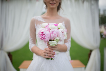 Bride with a beautiful purple wedding bouquetの写真素材
