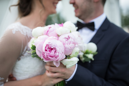 Bride and groom with a beautiful purple wedding bouquetの写真素材