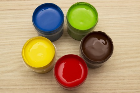 Finger paints in jars on a wooden backgroundの写真素材