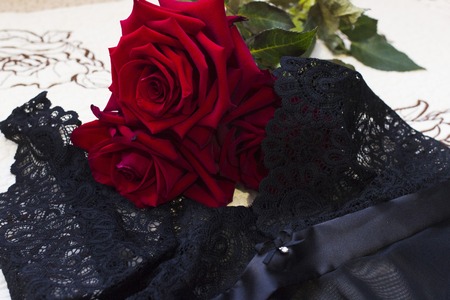 Red roses on a black lace lingerieの写真素材