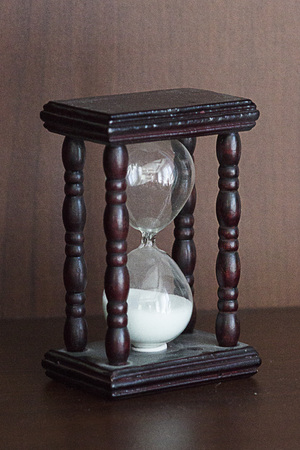 Hourglass with wooden case on wooden background