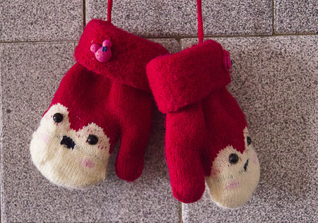 Red mitten on wooden background