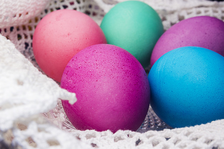 Colored Easter eggs on a white lace napkin