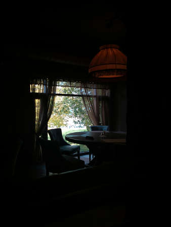 The light from the window illuminates the dining area in the dark room.の写真素材