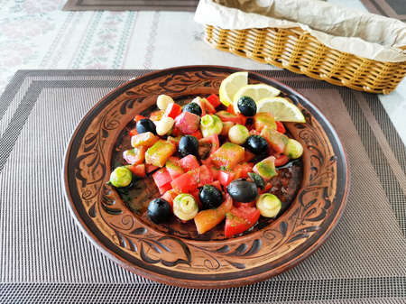 Mix vegetable salad with salmon, olives and champignon on a plate on a dark plateの写真素材