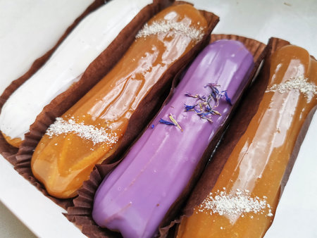 Eclairs set. Delicious sweets. Delicious French eclairs with icing, cream, salted caramel and...