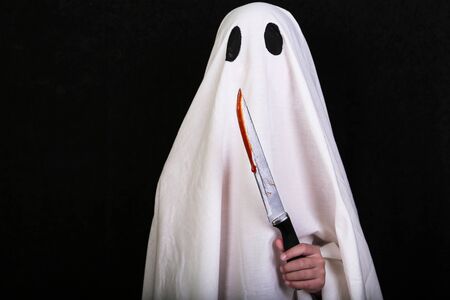 White Ghost with a knife in blood on black background. Halloween holiday party