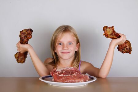 carnivore keto diet concept - little blond girl  eating raw meat. Health food.の写真素材