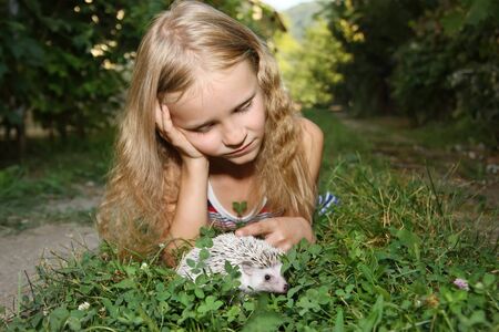 beautiful little girl with her pet African pygmy hedgehogの写真素材