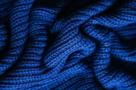 Classic blue dark knitted background. Close up texture . wrinkled and shadows, top view. 2020 trend color.の写真素材