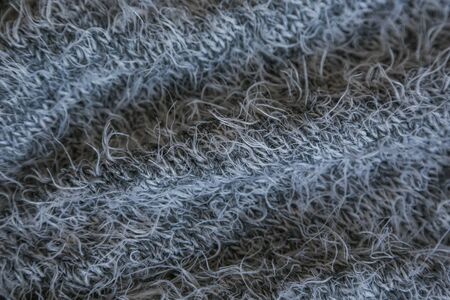 Gray knitted fabric background. Close up gray fabric texture background. wrinkled and shadows,...