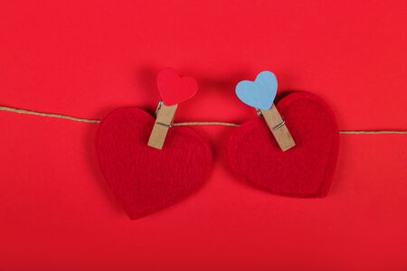 Greeting Card banner for Valentine's Day. Red hearts on rope with clothespins, on red background. Copy space.の写真素材