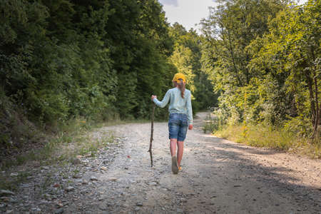 Happy hiker girl with walking stick walking in the mountains. Freedom, goal, hiking, children...