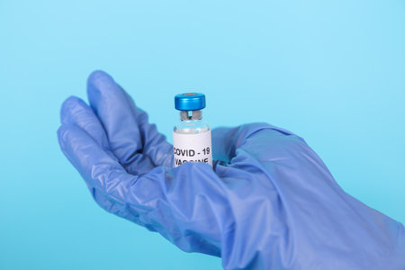 Banner. Doctor wearing gloves holding syringe with vaccine testing and prepares for injection. COVID-19 immunization.の写真素材