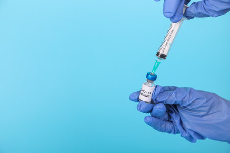 Banner. Doctor wearing gloves holding syringe with vaccine testing and prepares for injection. COVID-19 immunization.の写真素材