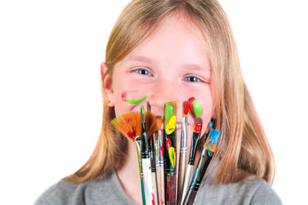 Happy child girl artist with brushes and palette in hands on white background. Painting education concept, art schoolの写真素材