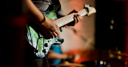 Rock music background, bass guitar player, closeup photo with selective focus and motion blur effectの写真素材