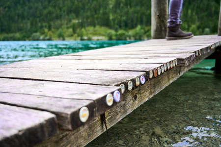 Bottle caps jammed at the edge of a jetty positioned above the plansee Austria.の写真素材