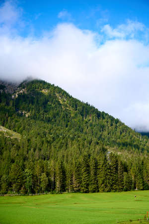Mountain in the Austrian Alps with blue sky above and white clouds around the mountain.の写真素材