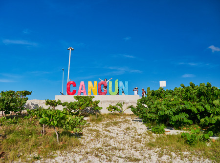 Girl lifts her arms up in front of Cancun sign, Playa Delfines, Mexico, in September 7 , 2018のeditorial素材
