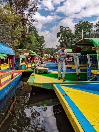Boy runs on boats moored in Xochimilcoのeditorial素材