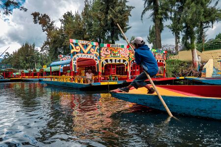 Young trajinero rows the trajinera into Xochimilco canalのeditorial素材