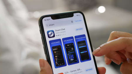 Young woman view the Steam chat game app on her smartphone at the time of the coronavirus quarantine, Mexico, April 30, 2020のeditorial素材