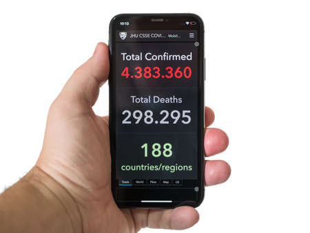Man hand holds smartphone with COVID-19 Coronavirus website Confirmed Cases with over 4 million sick people for Systems Science and Engineering at Johns Hopkins University, Mexico, May 14, 2020のeditorial素材