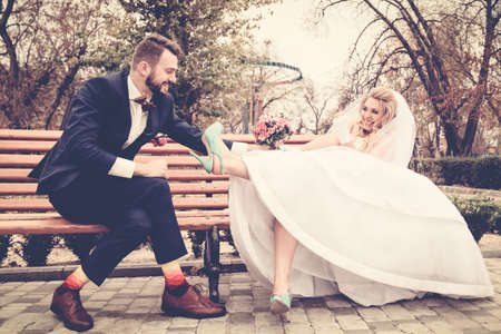 Bride and groom in bright clothes on the benchの写真素材