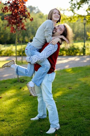 Young man is carrying his pretty girlfriendの写真素材