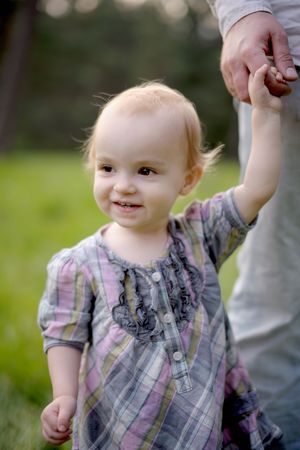 Nice little smiling baby holding father's handの写真素材