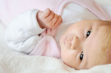 Sweet little newborn baby laying in a bedの写真素材